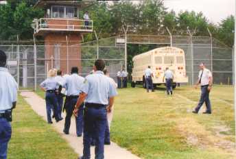 Staff watch as some of the last inmates leave the prison.