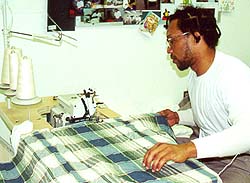 Inmate assembles blanket on sewing machine