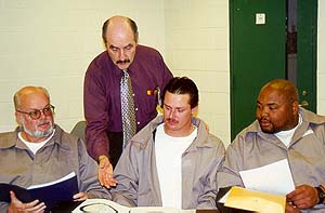 Joe Marinello (standing), contracted instructor at Albemarle Correctional Institution, talks with inmates Larry Phifer (from left to right), James Rogers and Walter McDowell. The inmates recently graduated from S.T.O.P. and Change Direction, a program aimed at educating offenders about domestic violence.